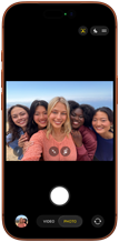 iPhone 17 Pro v kozmickej oranžovej farbe, pohľad spredu, na obrazovke je predná kamera Center Stage so skupinovým selfie piatich ľudí vycentrovaných v zábere